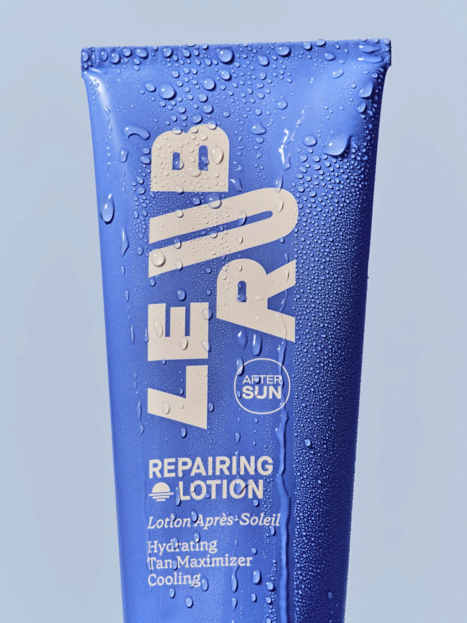 Le Rub After Sun Repairing Lotion in blue tube with water droplets, showcasing hydrating tan maximizer with minimalist design and 'After Sun' branding
