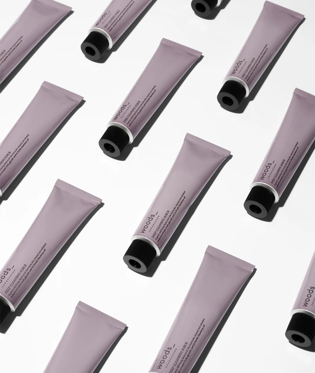 Woods Copenhagen Deep Cleansing Scrub | Multiple Lavender Skincare Tubes Geometric Layout
