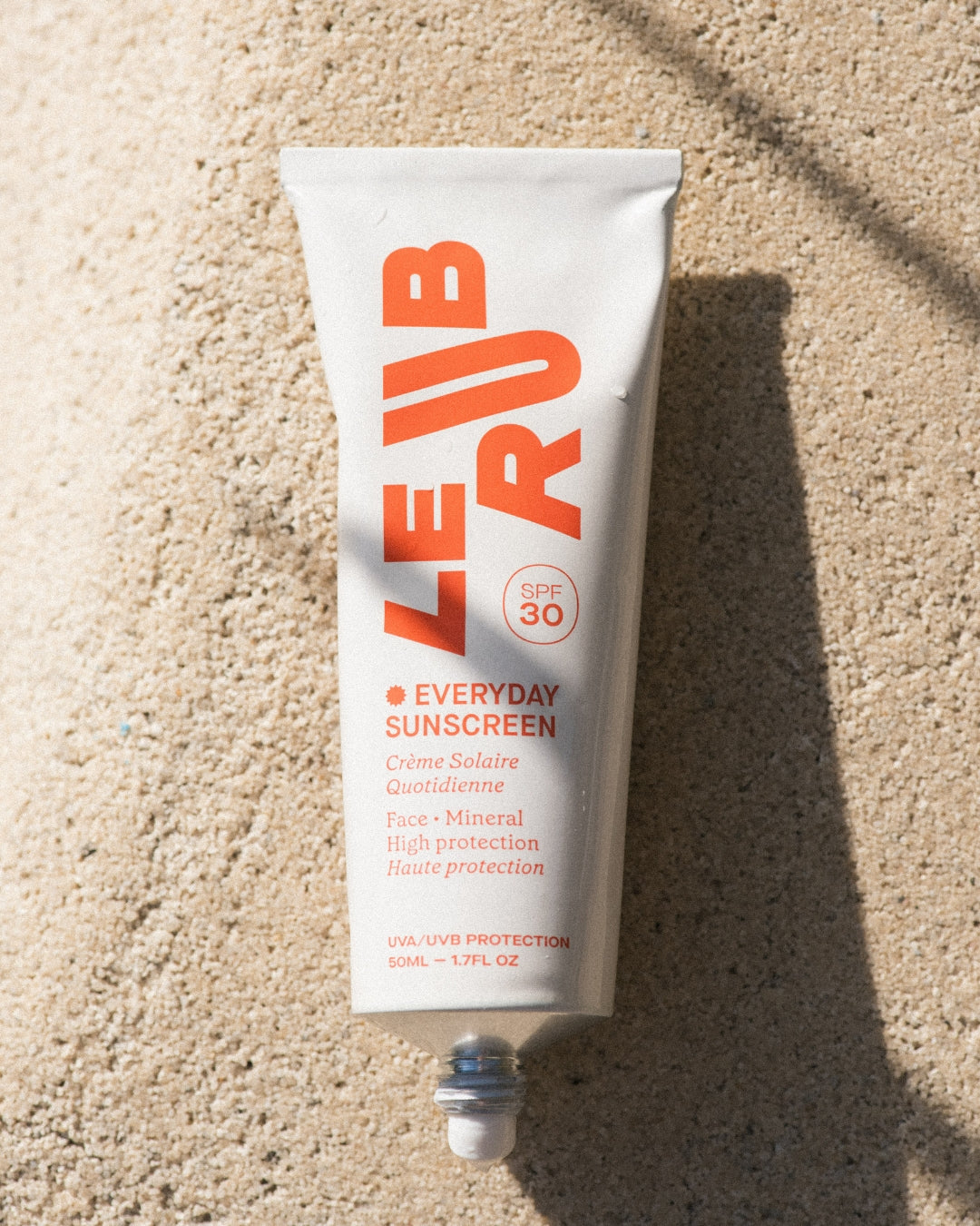 Le Rub sunscreen product being applied on skin, showcasing minimalist packaging and natural skincare application technique

