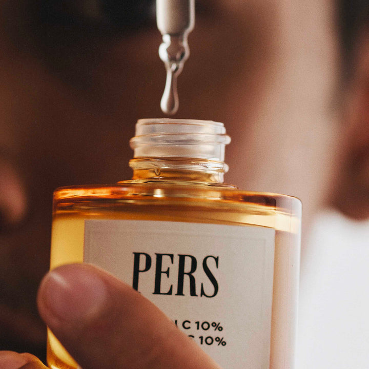 Close-up of PERS Vitamin C serum bottle with dropper above the opening