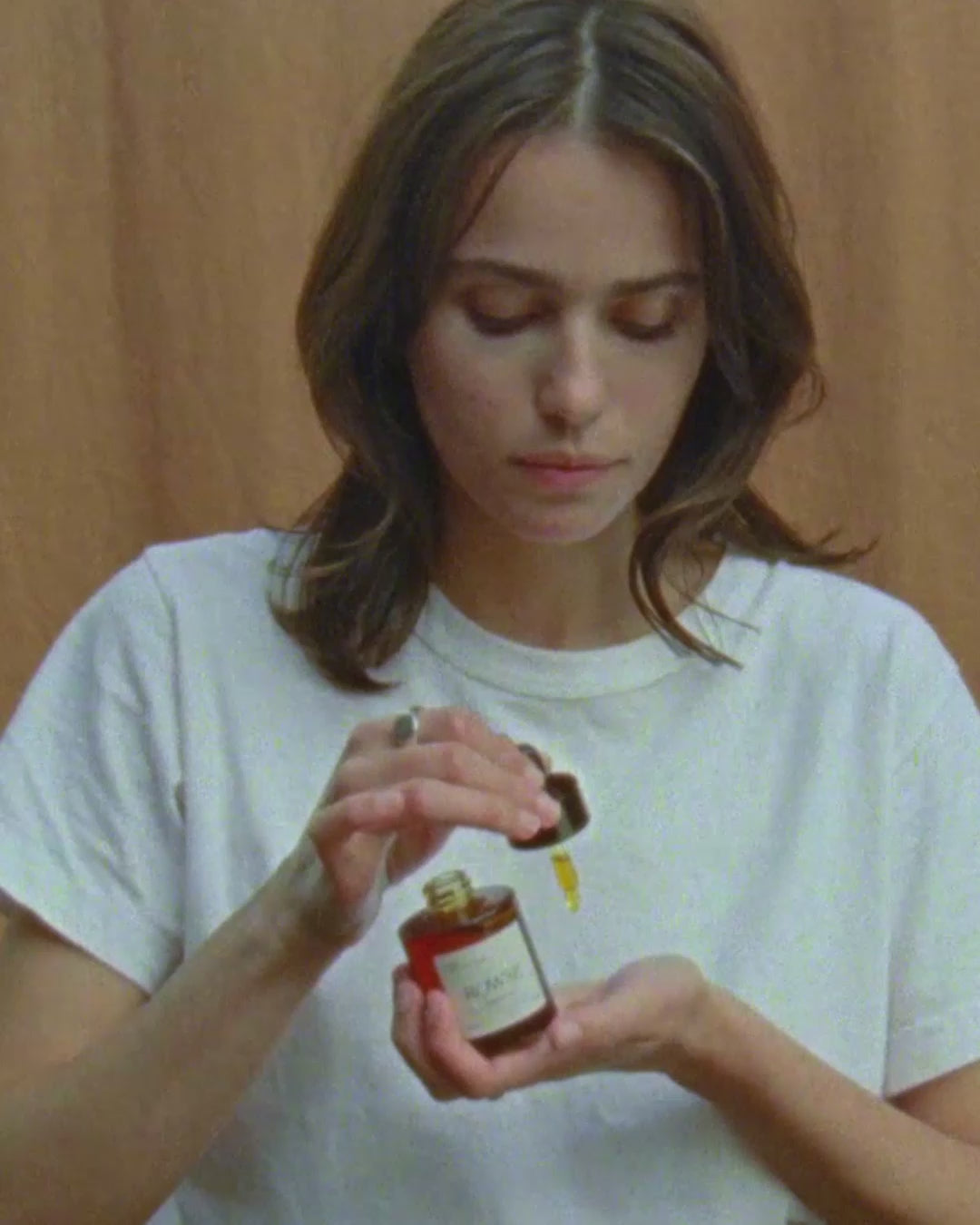 ROWSE Purify Night Oil being carefully applied, demonstrating precise nighttime skincare routine and oil absorption technique
