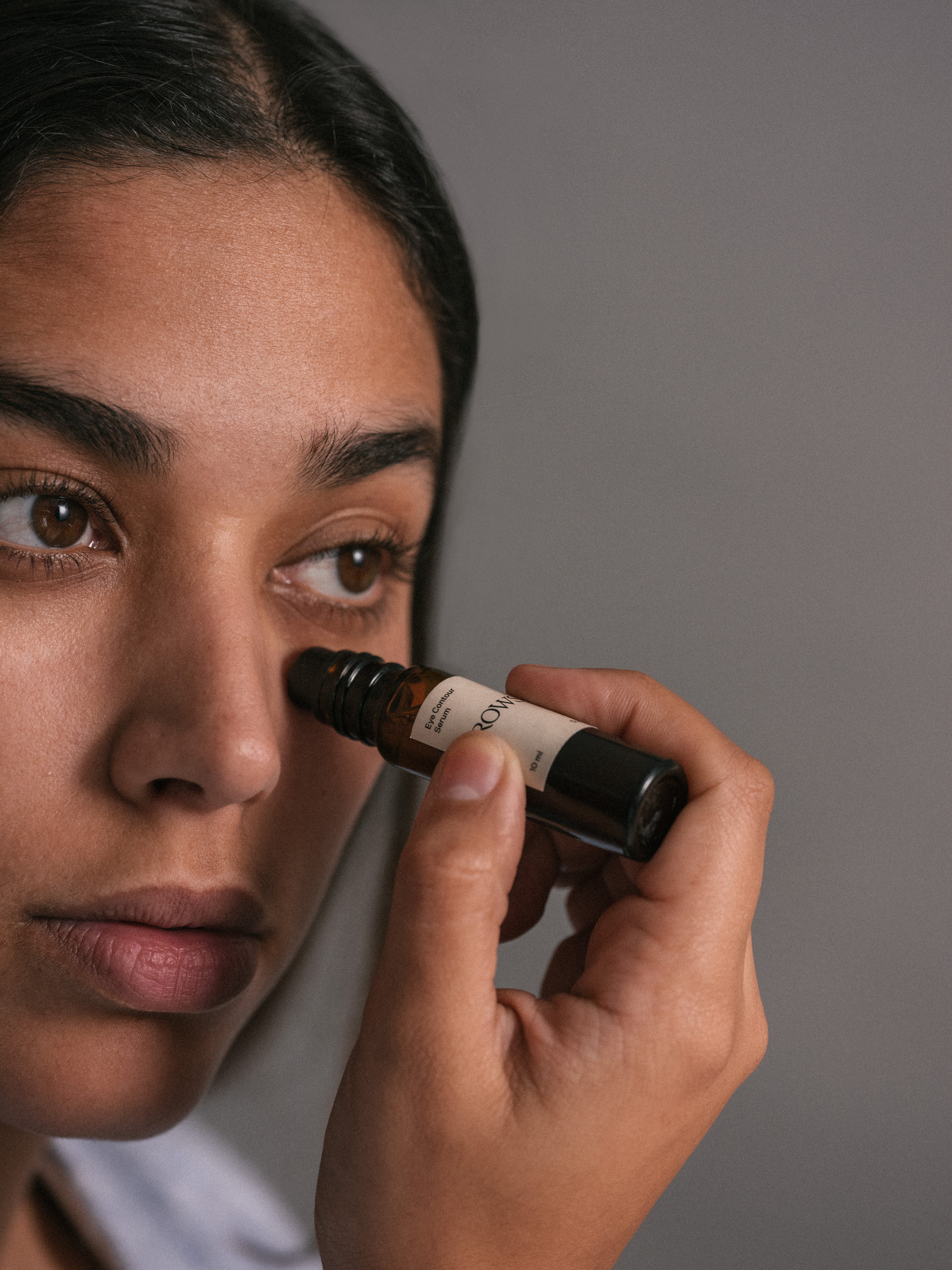 ROWSE Eye Contour Serum being delicately applied near the eye, showcasing precise skincare routine and targeted treatment for delicate eye area
