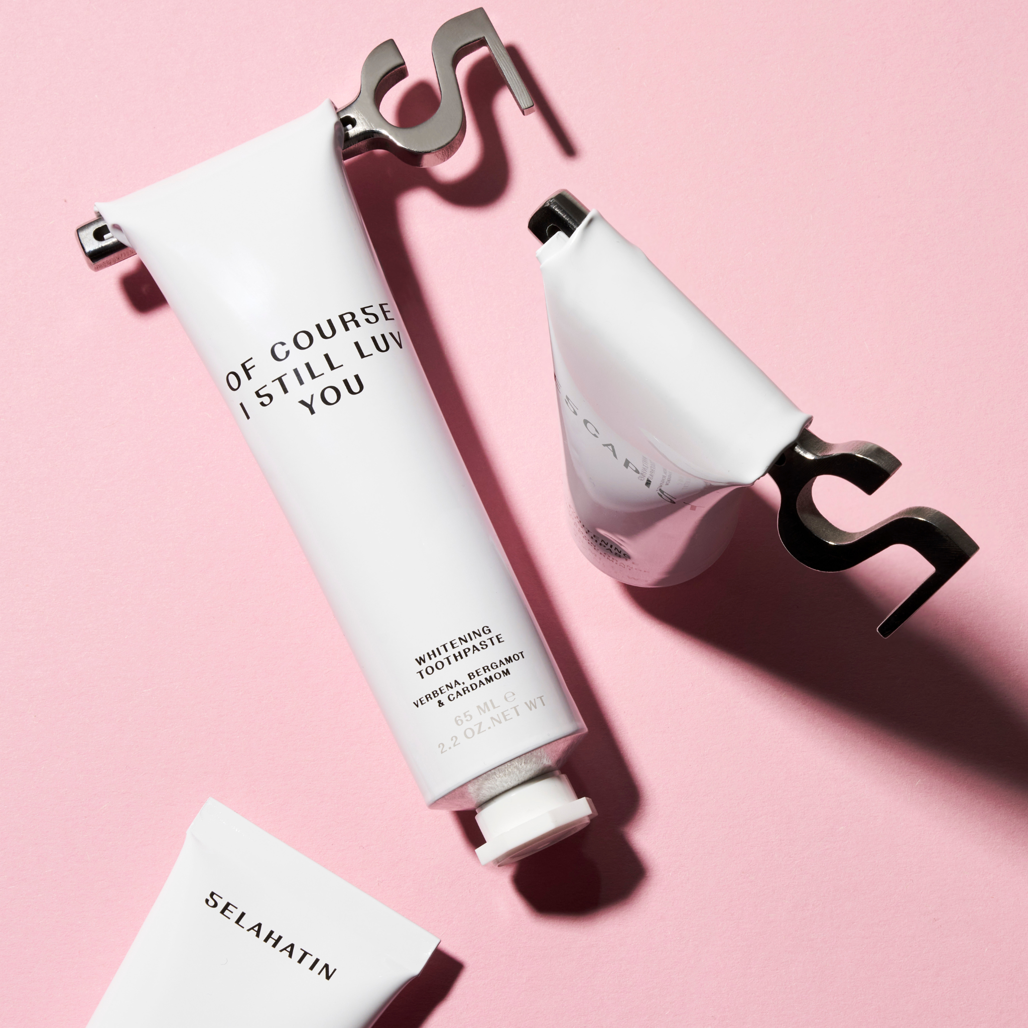 Selahatin whitening toothpaste collection with artistic pink background, featuring minimalist packaging and playful typography
