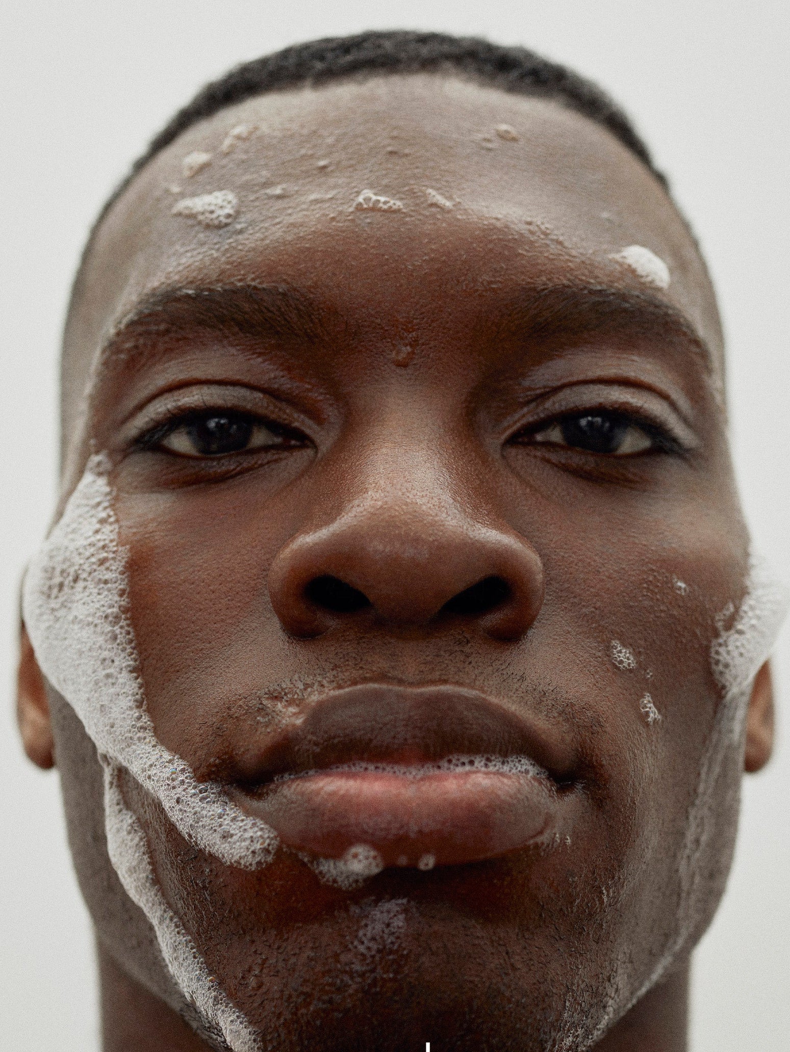 Woods Copenhagen Daily Foaming Cleanser lifestyle image featuring a man with gentle facial foam, showcasing clean, minimalist skincare routine with natural lighting