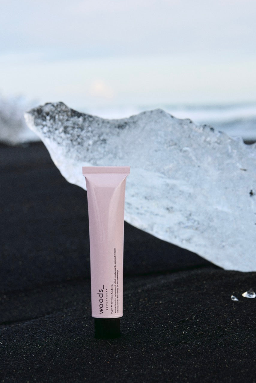 Woods Copenhagen Daily Mineral Gel in soft pink packaging, showcasing minimalist Scandinavian skincare design with natural, muted color palette