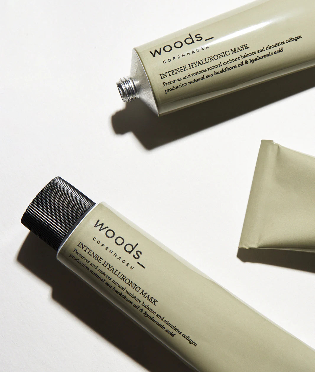 Woods Copenhagen Intense Hyaluronic Mask minimalist product tubes in neutral beige tones, showcasing clean Scandinavian skincare design